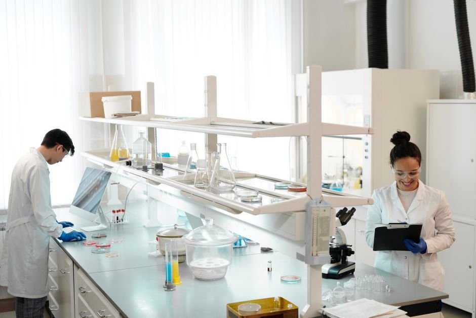 Two scientists working in a modern laboratory setting, analyzing and documenting experiments.